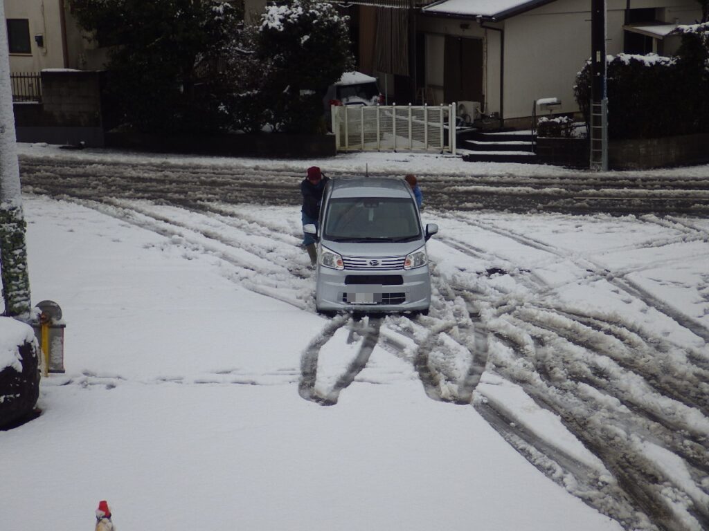 大雪で滑る社長の乗る軽自動車